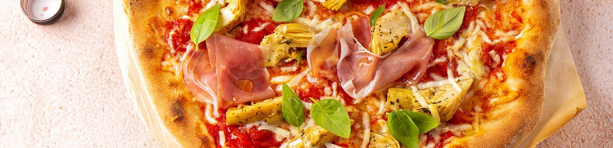 Pizza met tomaat, artisjok, prosciutto en pecorino