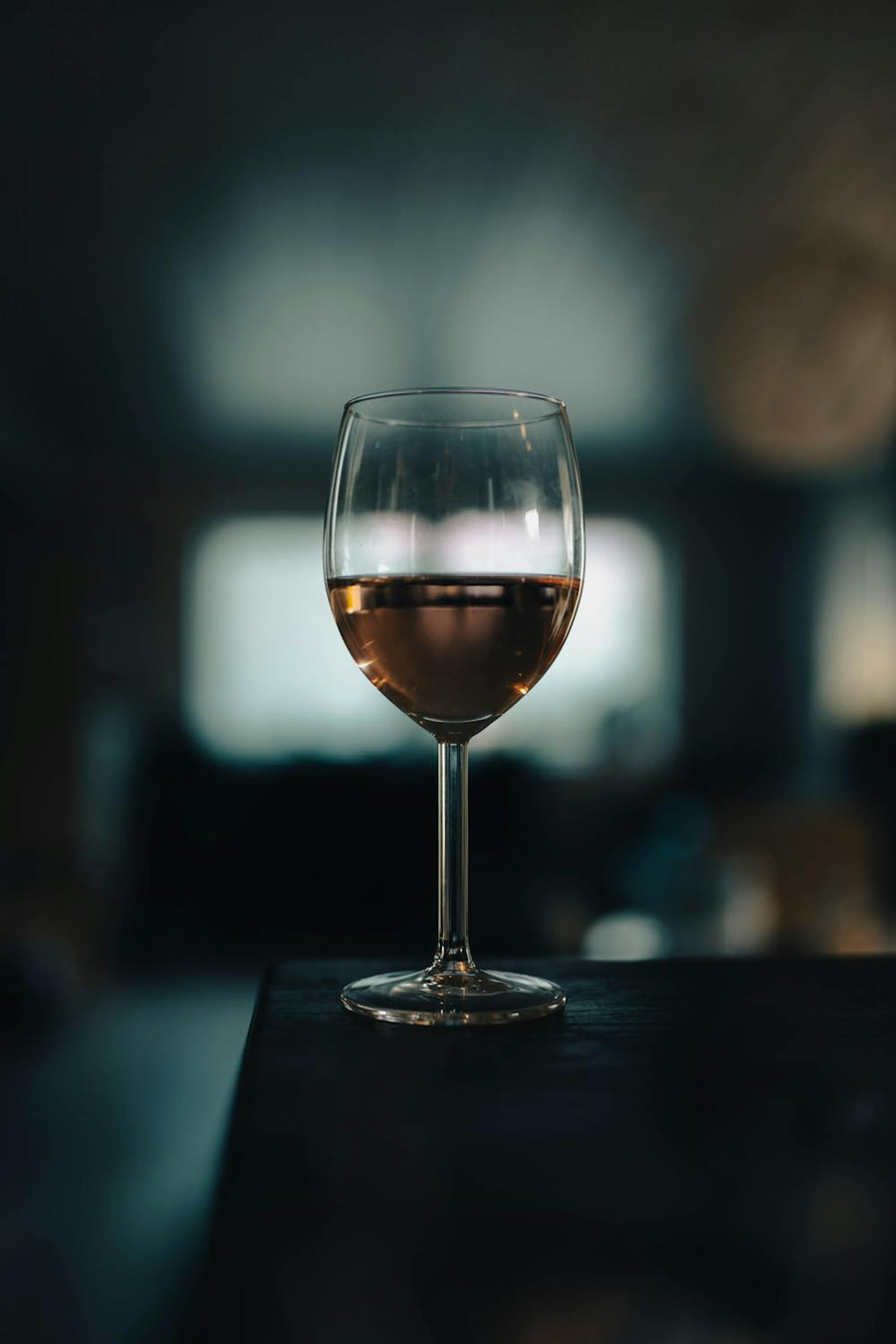 Glas rosé wijn in het donker