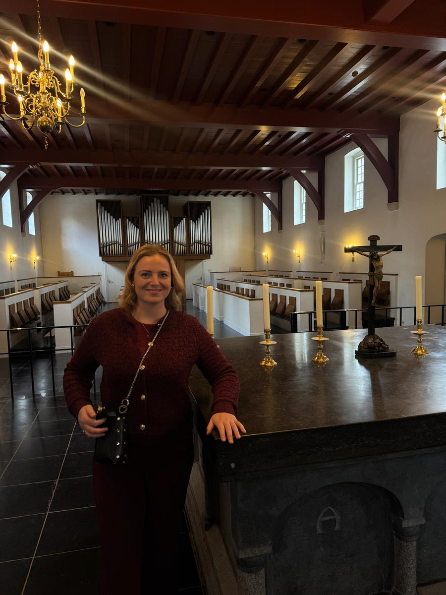 Nina in de historische kloosterkapel met kaarsen en orgel