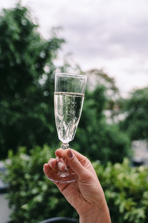 Vrouw geniet van een glas prosecco buiten in de zon