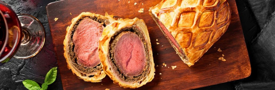 Beef Wellington aangesneden op houten plank