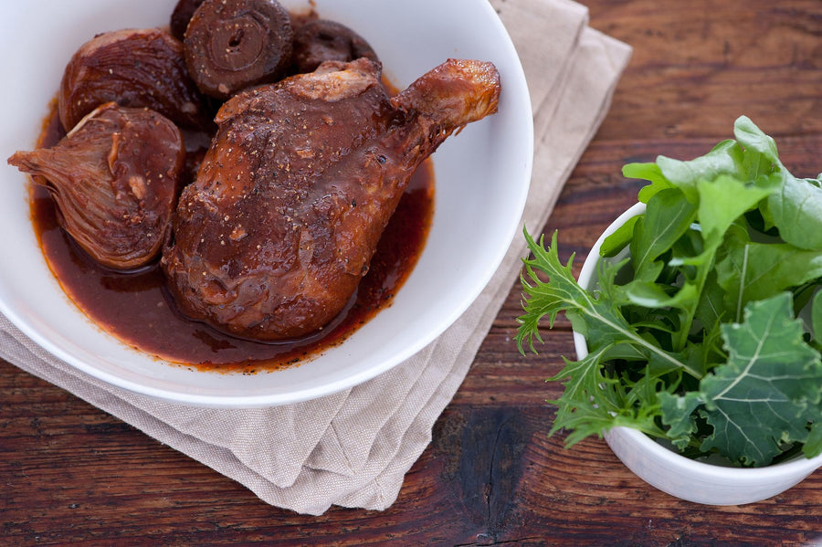 Coq au vin met groene salade in serveerschaal