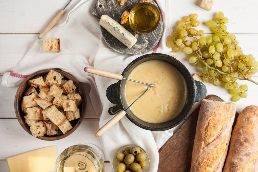 Glas witte wijn bij kaasfondue